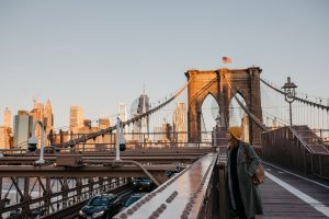 USA, New York, New York City, female tourist on Brooklyn Bridge in the morning light